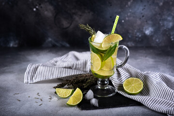Mojito cocktail with lime and mint in highball glass on a grey stone background Copy space