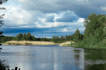 landscape rainy sky over the river on the background of the forest