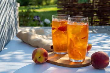 Fresh Homemade Peach Sweet Tea with ice cubes in glass.