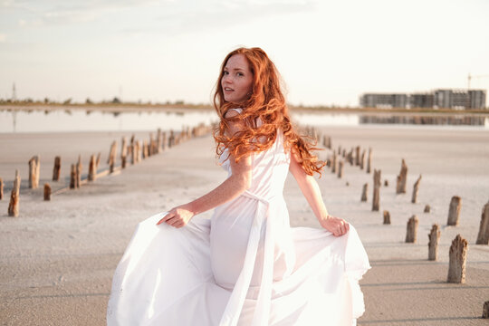 Beautiful young lady with long healthy red hair and cute dress