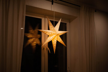 A Christmas star in the window. Warm light, Christmas, cosy atmosphere. Advent time.