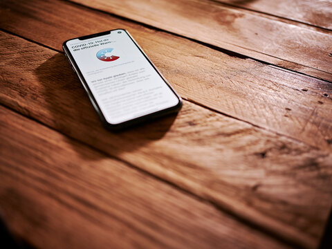 Corona-Warn-App auf iPhone auf Holztisch