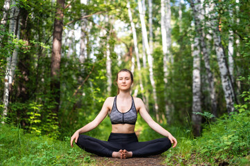 Beautiful Girl practicing yoga in the park