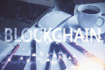 Multi exposure of blockchain and crypto economy theme hologram and table with computer background. Concept of bitcoin cryptocurrency.