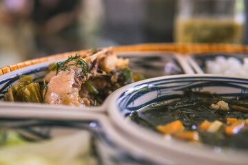 rice bowl with rattan, inside is traditional Vietnamese lunch, rice, soup, salty food. The scene is frugal and peaceful.