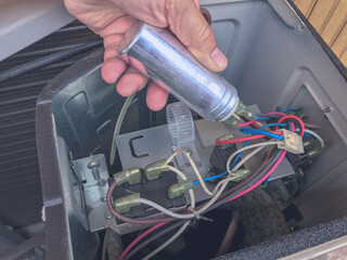 Air conditioner repair by technician. The technician replace the capacitor run of air conditioner....