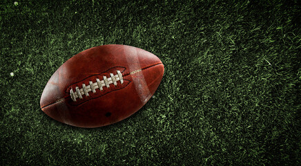 American football ball on grass background