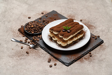 Classic tiramisu dessert on ceramic plate on concrete background