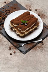 Classic tiramisu dessert on ceramic plate on concrete background