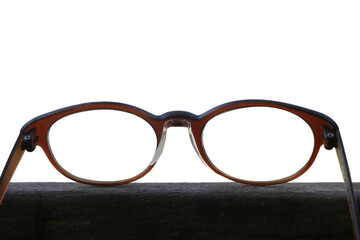 Eye glasses placed on a wooden floor in a white background