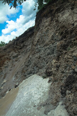An excavator digs a large trench for building a house. A tractor digs a large lake that is already gaining water. Stock background for design