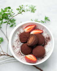 Homemade chocolate and nuts candy balls with cocoa powder, coconut, strawberries and chopped hazelnuts