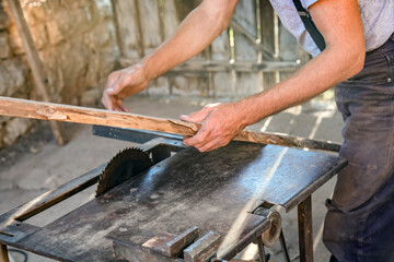 Carpenter using vintage electric circular saw.