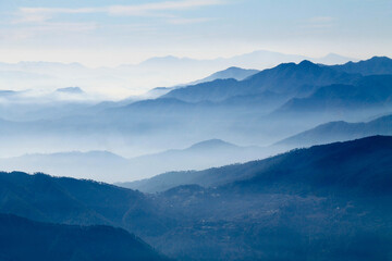 Fototapeta na wymiar mountains in the fog. Misty mountain blue. Himalayan mountain range in uttrakhand Brahmatal. 