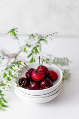 fresh Cherry on white bowl with flowers