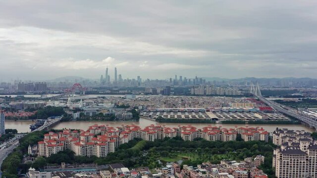 Open view of Guangzhou metropolis city with living blocks, river and Downtown buildings in far distance, on a cloudy overcast day .Guangdong, China.
