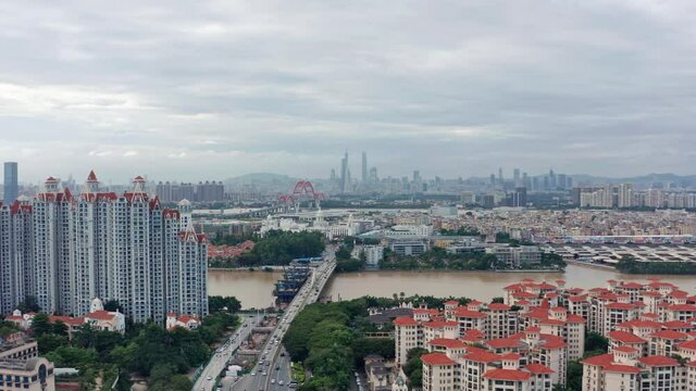 Open view of Guangzhou metropolis city with living blocks, river and Downtown buildings in far distance, on a cloudy overcast day .Guangdong, China.
