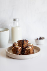Homemade chocolate vegan brownies with coconut milk on white table