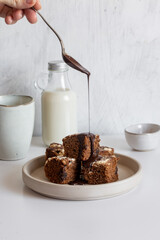 Homemade chocolate vegan brownies with coconut milk on white table