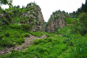 Beautiful waterfall in the mountains. Eco Tourism, eco travel. Mountain landscape, valley of mountains. Waterfall among stones and rocks.