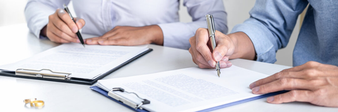 Contract decree of divorce (dissolution or cancellation) of marriage, husband and wife during divorce process and signing of divorce contract, Wedding ring