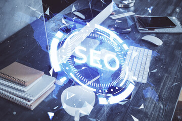 Multi exposure of table with computer and seo drawing hologram. Search optimization concept.