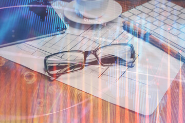 Financial chart hologram with glasses on the table background. Concept of business. Double exposure.