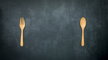 wooden spoon and fork on dark blue background with copy space