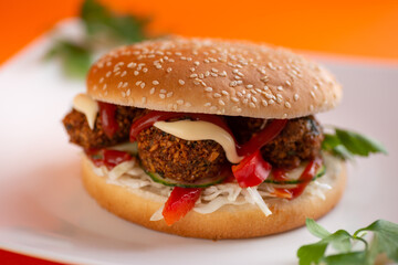 Falafel vegetarian burger with vegetables isolated on white plate