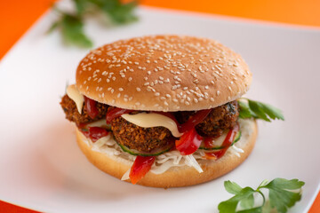 Falafel vegetarian burger with vegetables isolated on white plate
