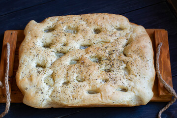 focaccia dough in a baking dish. Traditional Italian Focaccia with rosemary