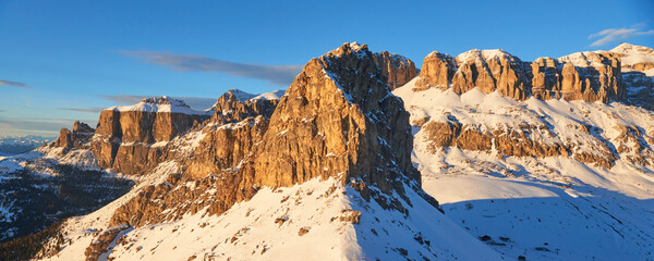 Winter panoramic view of rocky mountains at sunset in the Dolomites range near Val Gardena ski resort in Italy.