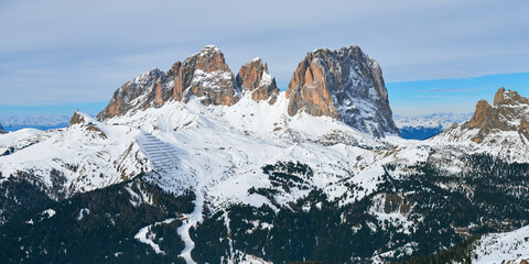 Obraz premium Winter panoramic view of rocky mountains and ski pistes in the Dolomites range in Italy.