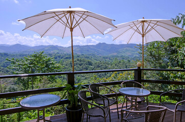 White umbrellas with coffee tables and chairs on balcony