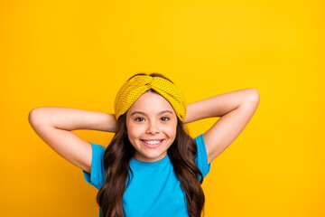 Closeup photo of beautiful little lady model hold arms behind head peaceful resting relaxation moment good mood wear casual blue t-shirt headband isolated yellow color background