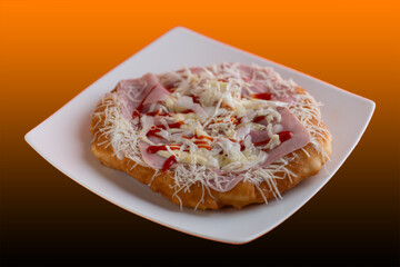 Traditional Transylvanian hungarian pastry, deep fried dough langos close up on white plate with Ham andcheese