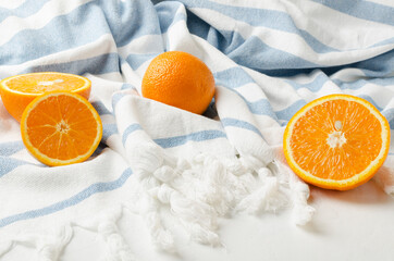 Closeup of slices of oranges on the striped blanket.Concept of relaxation on the beach and juicy fruits as a snack