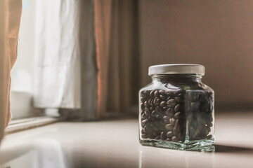 Roasted coffee beans are stored in a sealed glass jar to control the temperature to prevent humidity because it can spoil the coffee and cause mold.