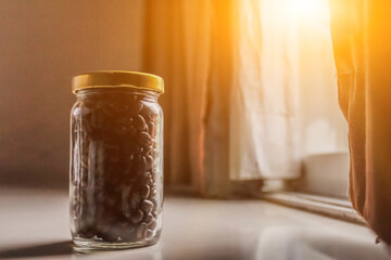 Roasted coffee beans are stored in a sealed glass jar to control the temperature to prevent humidity because it can spoil the coffee and cause mold.