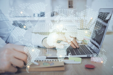 Multi exposure of businessman working on laptop on background. International business hologram in...
