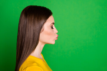 Fototapeta premium Close-up profile side view portrait of nice-looking attractive lovable affectionate dreamy straight-haired girl sending air kiss 14 February isolated bright vivid shine vibrant green color background