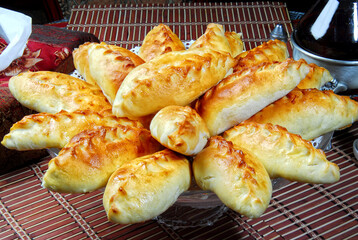 Group of individual pies with meat and potato - vak balish. Tatar traditional pies. Wooden background. Top view.