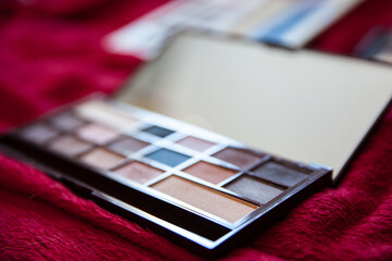 Close up of eye shadow palette with mirror on red background