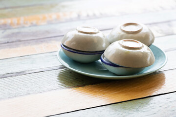 Streaming coconut milk custard in small porcelain cup. Thai dessert.