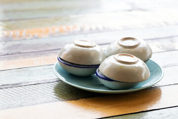 Obraz na płótnie Canvas Streaming coconut milk custard in small porcelain cup. Thai dessert.