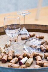 Wine glasses surrounded by bottle stoppers standing on a barrel