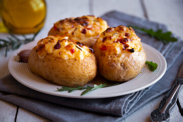 Baked potatoes stuffed with cheese, vegetables and rosemary