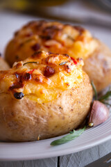 Baked potatoes stuffed with cheese, vegetables and rosemary