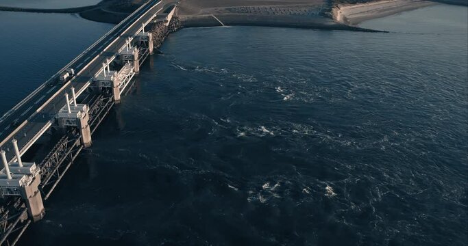 aerial of water stream from sea sluices, bridge over dam Delta works