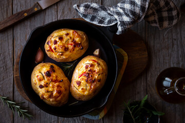 Baked potatoes stuffed with cheese, vegetables and rosemary